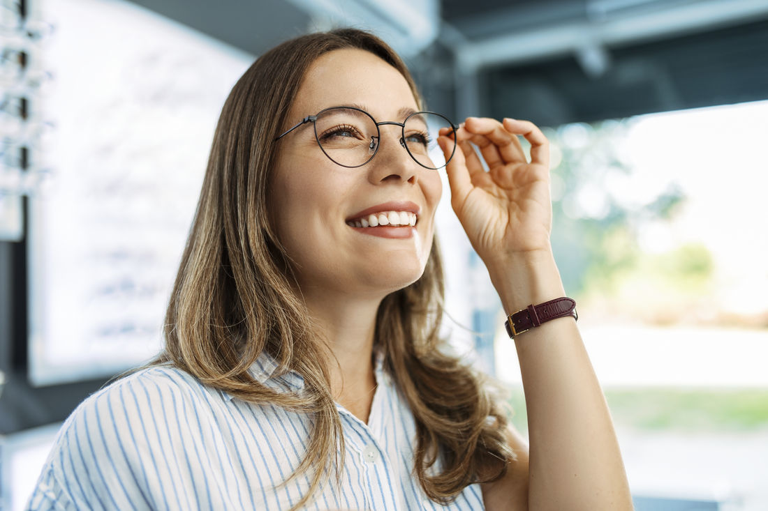 woman smiling holding glasses